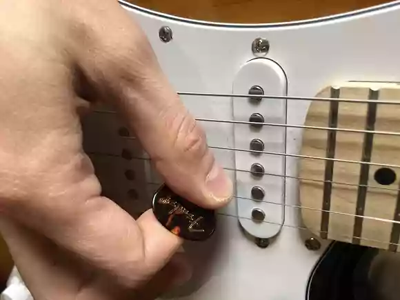 ピックを深く持つ手とギター